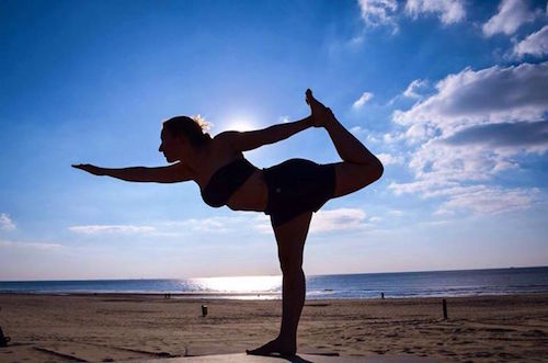 Woman on beach in Dancer's Pose